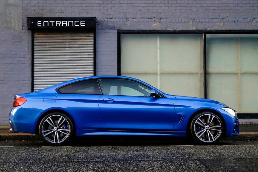 A clean blue sedan parked on a city street