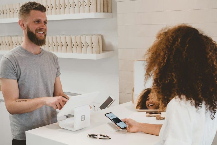 A small-business owner helping a customer at a shop counter